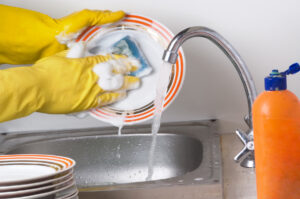 Man hands washing the dishes at kitchen